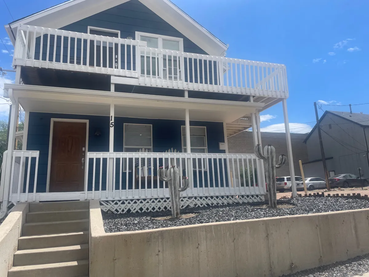 The image captures the home's inviting front porch adorned with cacti and featuring blue exterior paint. The porch provides a glimpse of the property's welcoming curb appeal and hints at its proximity to the downtown action, while also suggesting a relaxing spot to enjoy the neighborhood atmosphere.